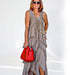 Woman wearing a stylish beige long dress made of chiffon, accessorized with a red handbag and sunglasses.